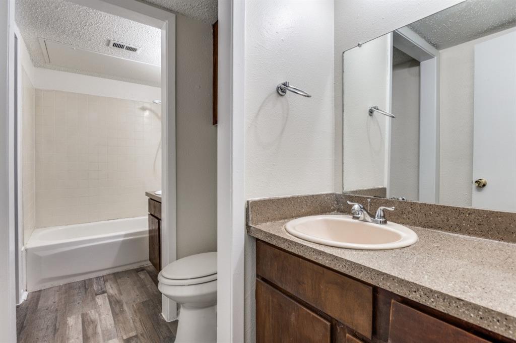 3930 Portland Street, Unit 3932 Irving, TX 75038 - Photo 11 of 12 a bathroom with a granite countertop sink toilet and shower
