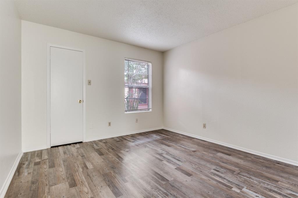 3930 Portland Street, Unit 3932 Irving, TX 75038 - Photo 5 of 12 an empty room with wooden floor and windows