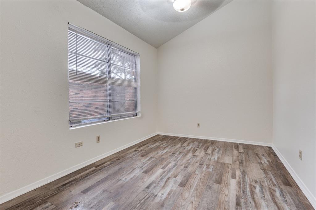 3930 Portland Street, Unit 3932 Irving, TX 75038 - Photo 6 of 12 an empty room with wooden floor and windows