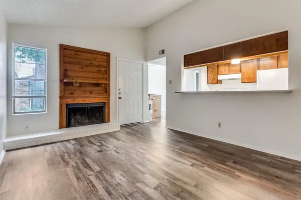 a view of an empty room with a window and fire place