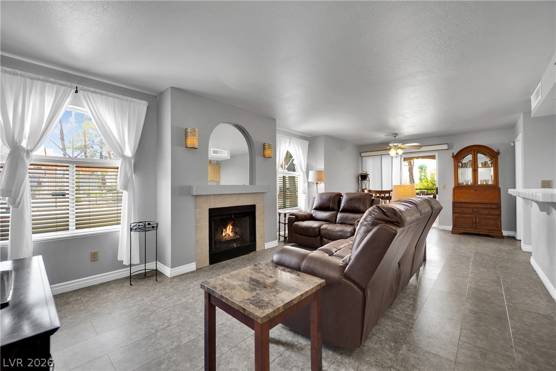 7570 West Flamingo Road, Unit 115 Las Vegas, NV 89147 - Photo 1 of 34 A comforting fireplace forms the centerpiece of this living area, featuring durable tile flooring and access to outdoor space.