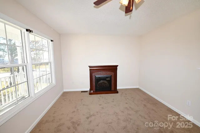 an empty room with windows and fan