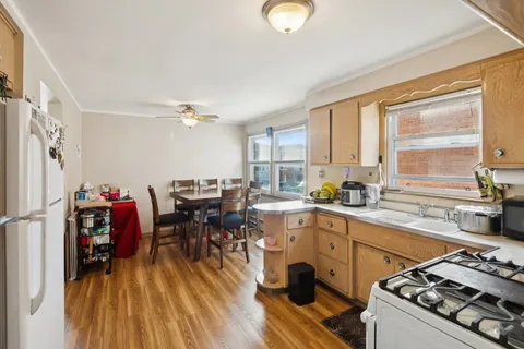a kitchen that has a lot of cabinets in it and wooden floors