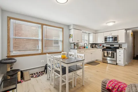 a kitchen with stainless steel appliances kitchen island granite countertop a dining table chairs and granite counter tops