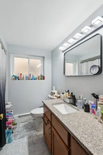 a bathroom with a granite countertop sink and a mirror