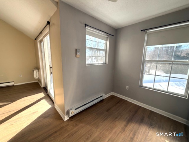 113 Heather Ridge, Unit 113 Shelton, CT 06484 - Photo 9 of 19 an empty room with wooden floor and windows