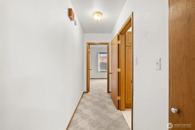 a view of a hallway with wooden floor and closet