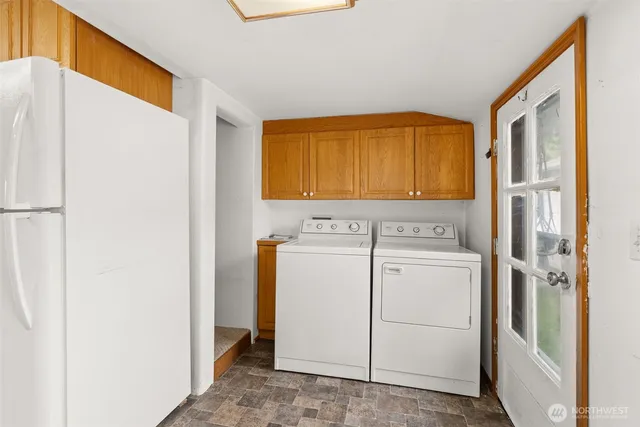a view of washer and dryer with kitchen in the background