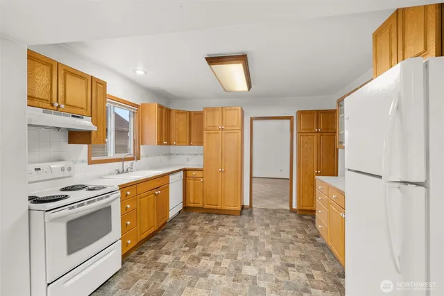 a kitchen with stainless steel appliances granite countertop a stove a refrigerator and a sink