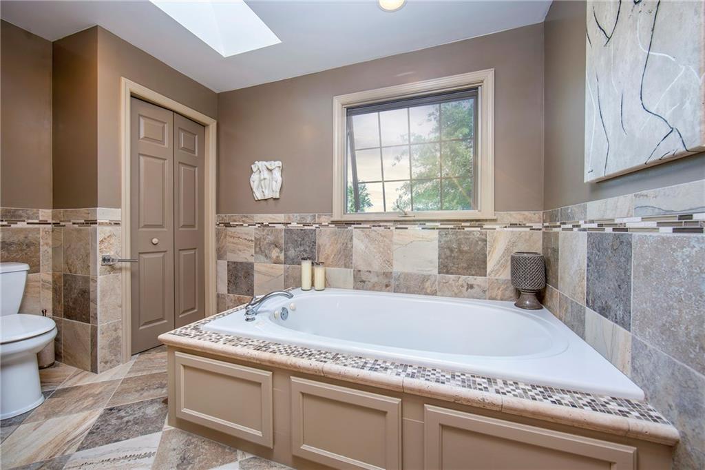 1479 Three Degree Road Mars, PA 16046 - Photo 13 of 24 Luxurious bath with oversized tile on walls and floor. Jet spray tub. Skylight, linen closet and a large, walk-in shower ....