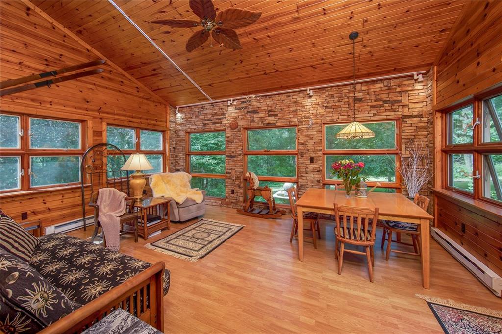 1479 Three Degree Road Mars, PA 16046 - Photo 4 of 24 Original vaulted porch was converted into this fabulous 4-season addition with 3-sides knotty pine and one side stacked stone with track lighting and large tropical fan. Gorgeous views via the awning windows in every direction! Zoned heating. Walk-out to patio which adjoins the deck and fireplace.