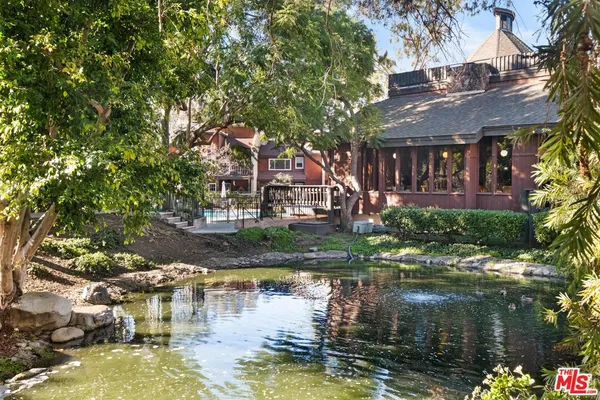 a view of house with swimming pool and outdoor seating
