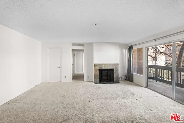 a view of an empty room with a fireplace