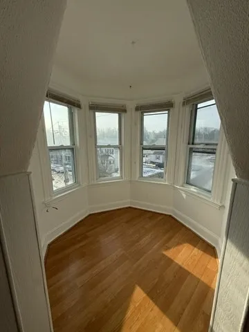 a view of empty room with wooden floor