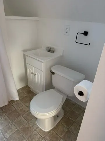 a white toilet sitting next to a window