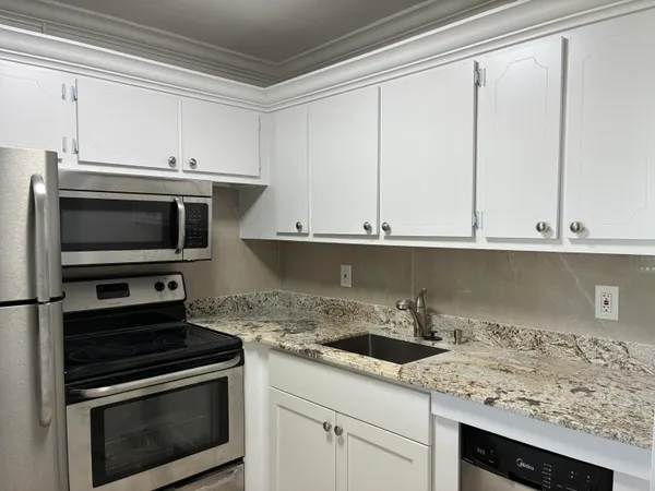 a kitchen with a sink stove and microwave