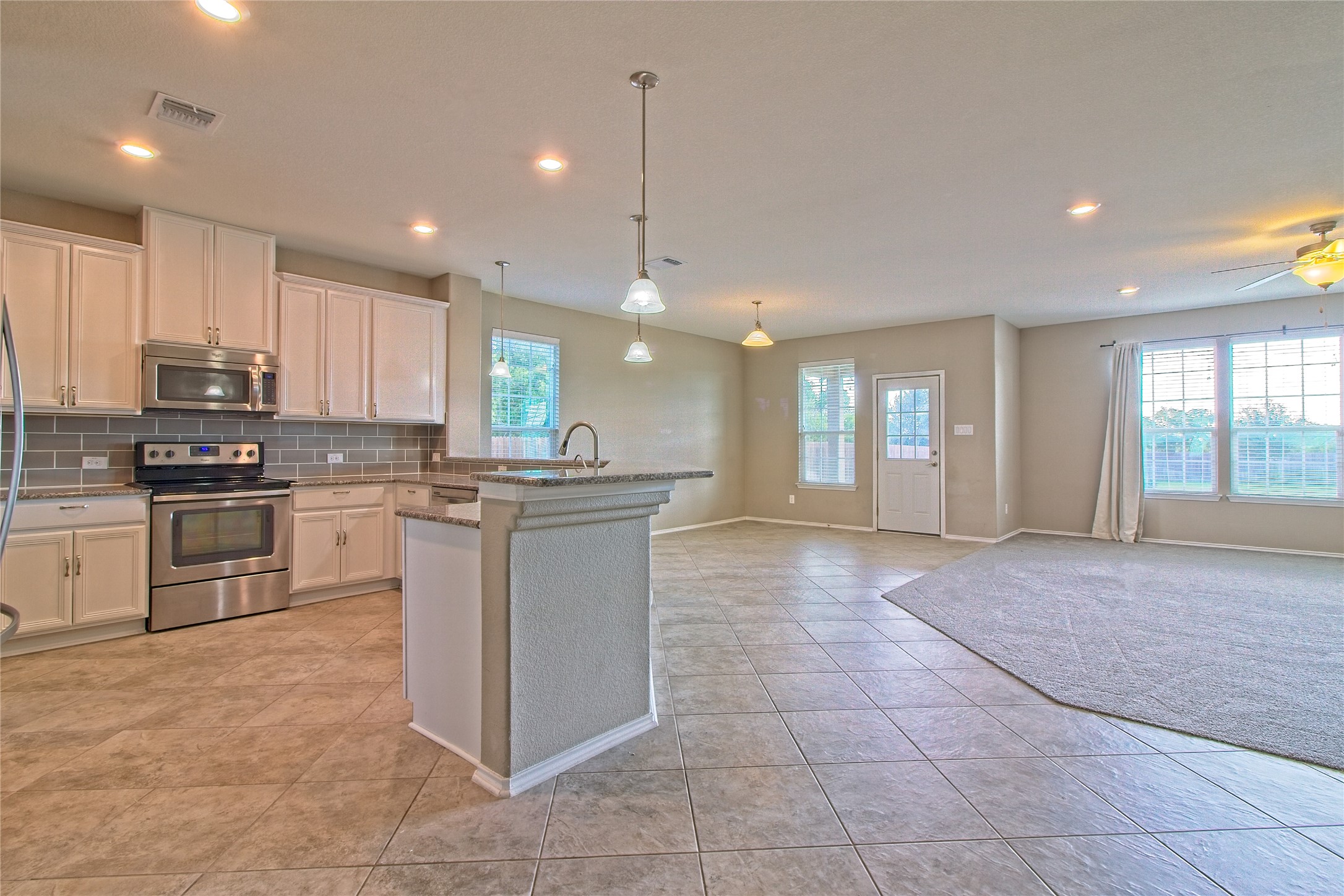 31443 Kingsway Road Georgetown, TX 78628 - Photo 8 of 40 An open concept design seamlessly connects the kitchen and living area, featuring ample cabinetry and a functional island.