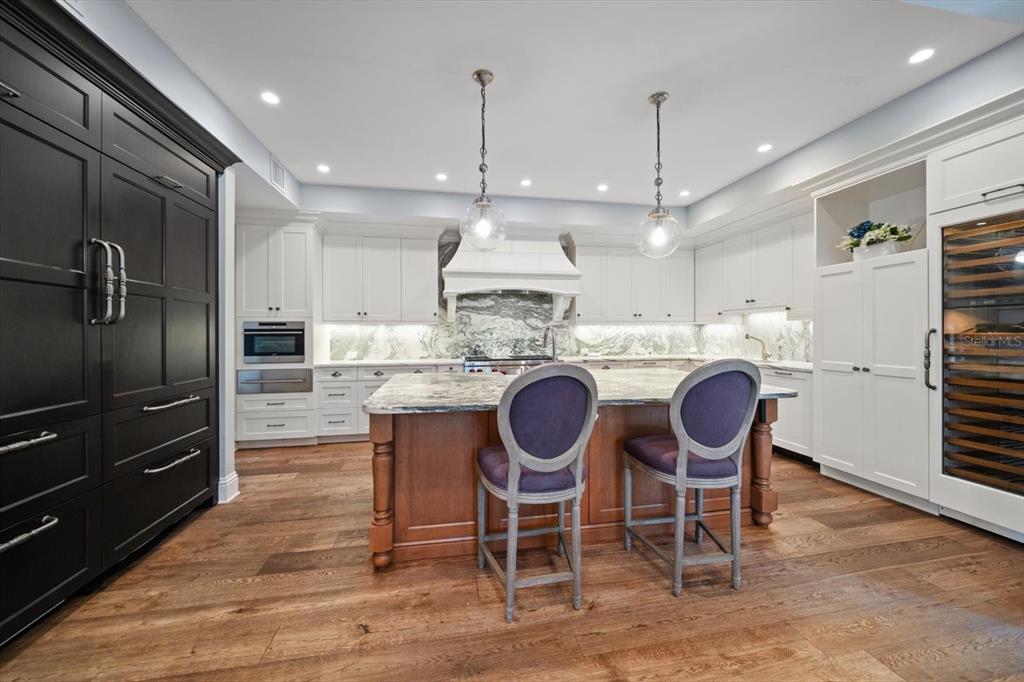 1102 Palmview Avenue Belleair, FL 33756 - Photo 18 of 81 a kitchen with stainless steel appliances granite countertop a stove a refrigerator a kitchen island a table and chairs