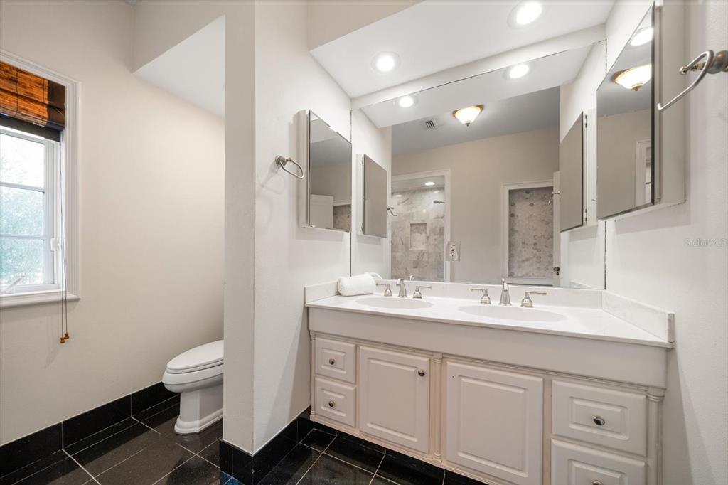 1102 Palmview Avenue Belleair, FL 33756 - Photo 39 of 81 a spacious bathroom with a double vanity sink a toilet and a mirror