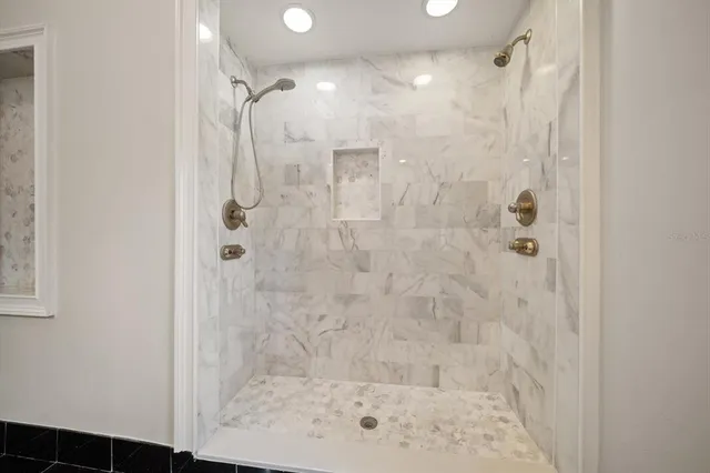 a living room with couches painting on the wall and a potted plant