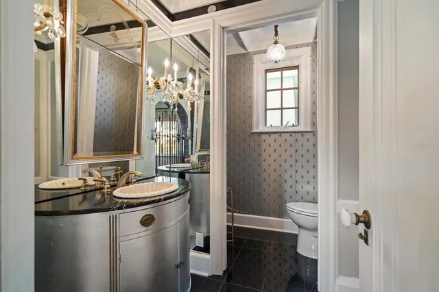 a living room with furniture a chandelier and a fireplace