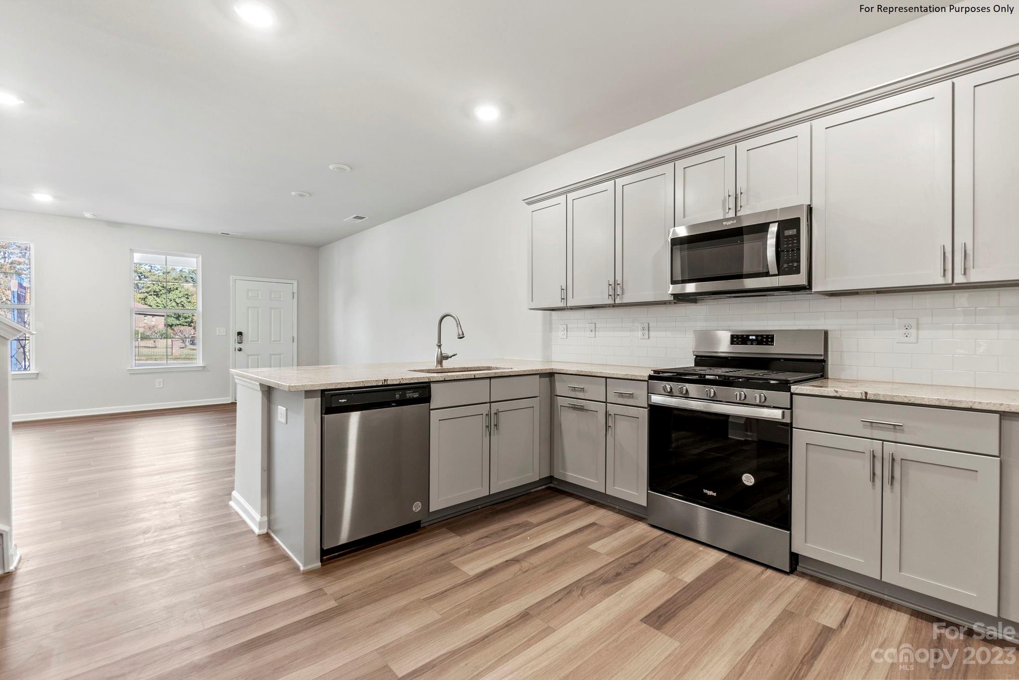 1948 Plath Top Road, Unit 24 Rock Hill, SC 29732 - Photo 12 of 44 a kitchen with stainless steel appliances granite countertop a stove a sink and a microwave