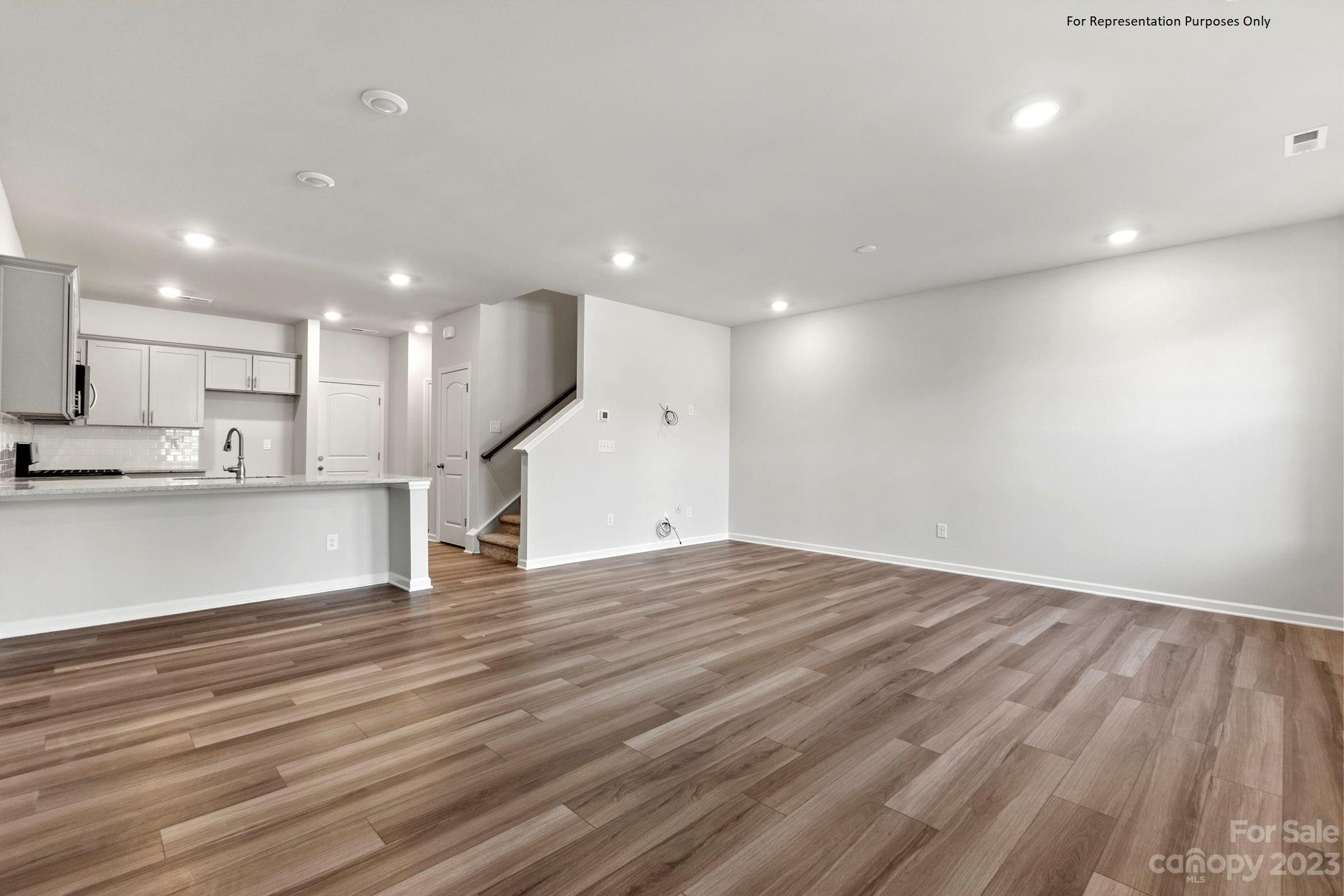 1948 Plath Top Road, Unit 24 Rock Hill, SC 29732 - Photo 6 of 44 an empty room with wooden floor and kitchen view