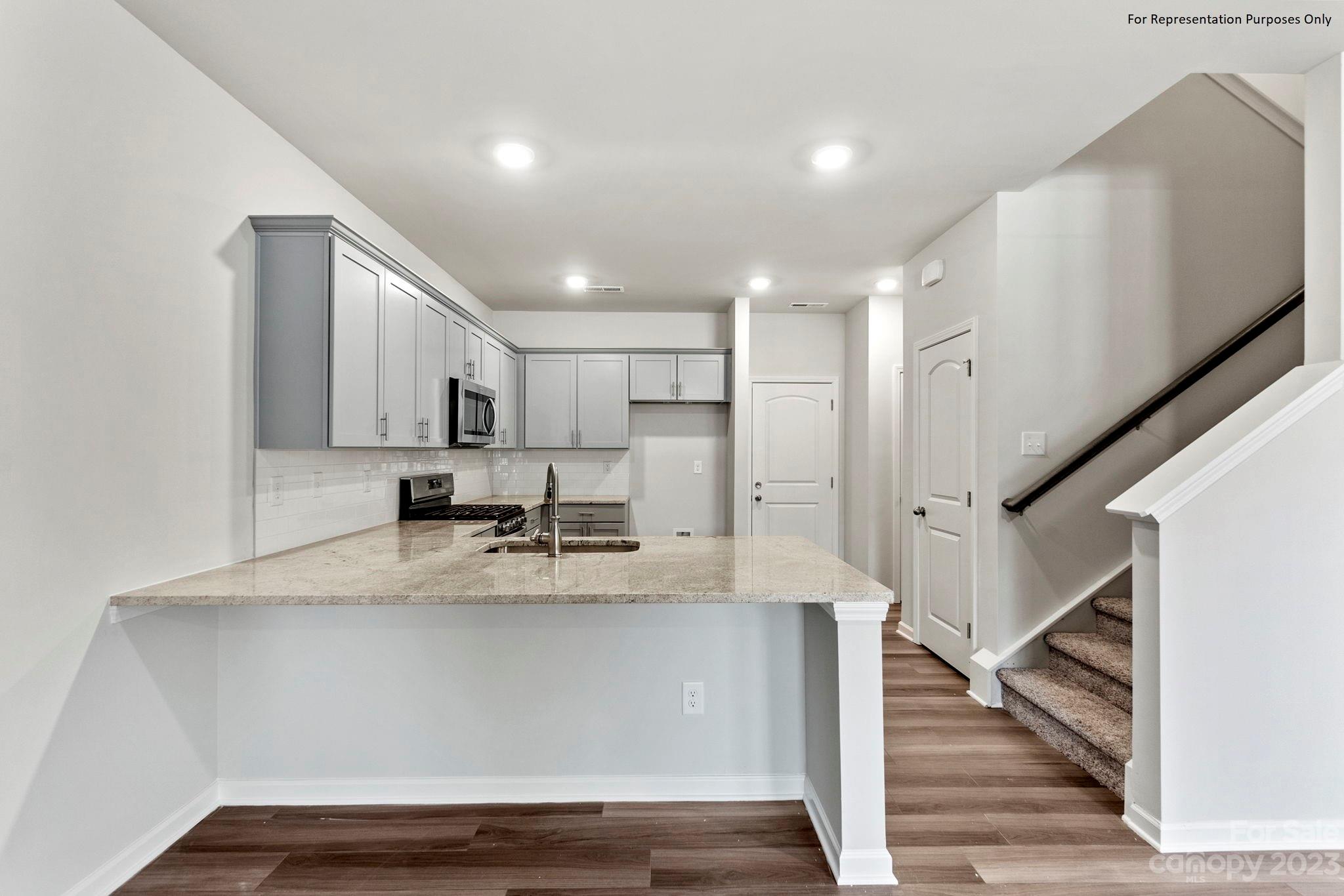 1948 Plath Top Road, Unit 24 Rock Hill, SC 29732 - Photo 10 of 44 a view of a kitchen with kitchen island a sink wooden floor and glass doors