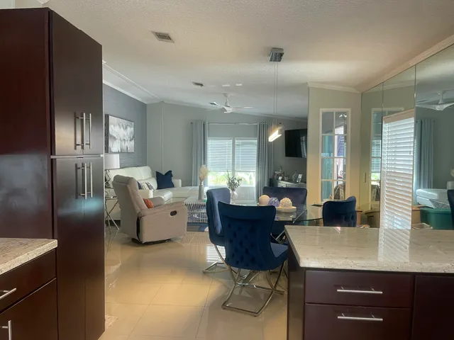 a living room with furniture a large window and kitchen view