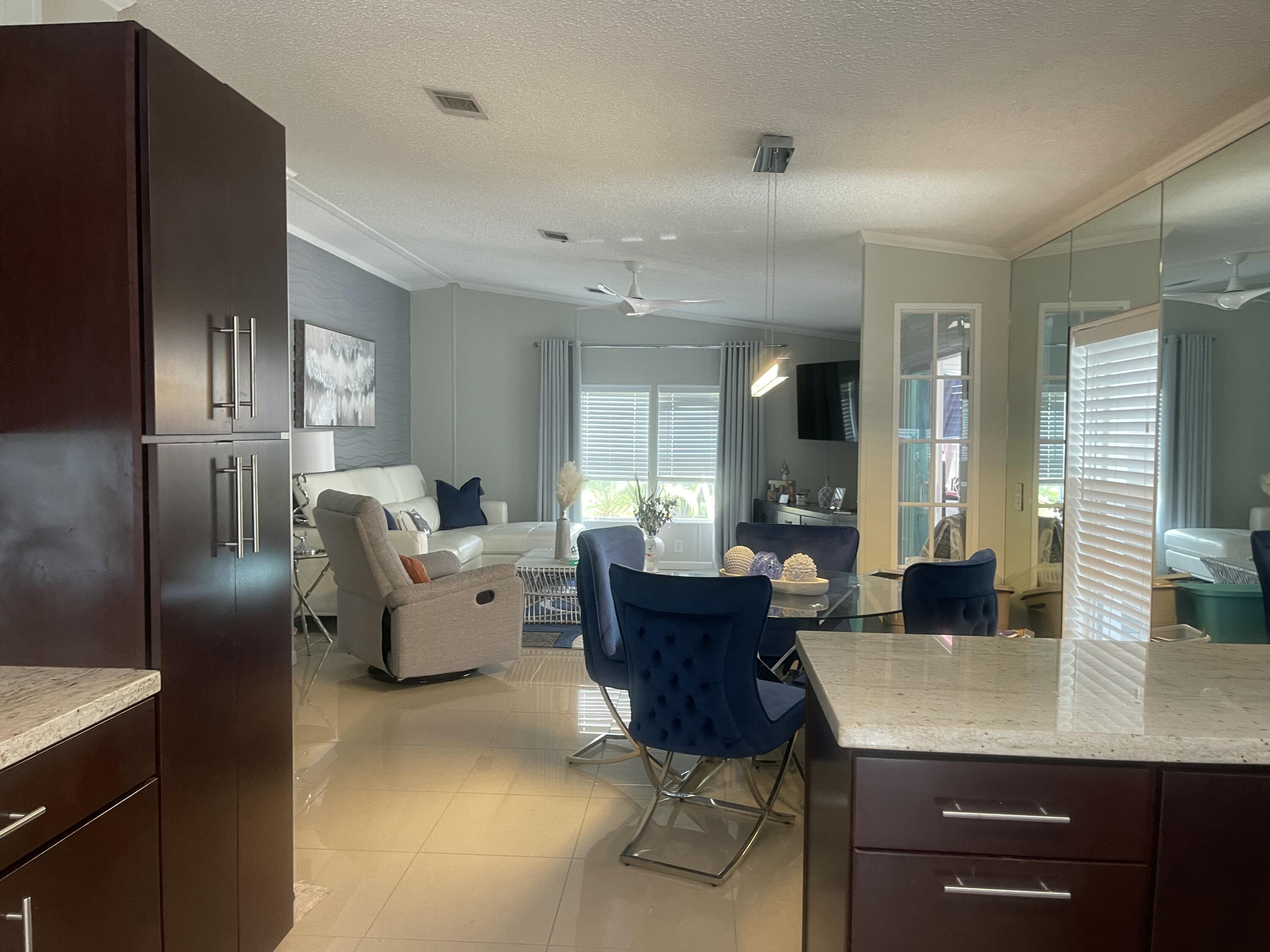817 Sunglow Street Boynton Beach, FL 33436 - Photo 2 of 15 a living room with furniture a large window and kitchen view
