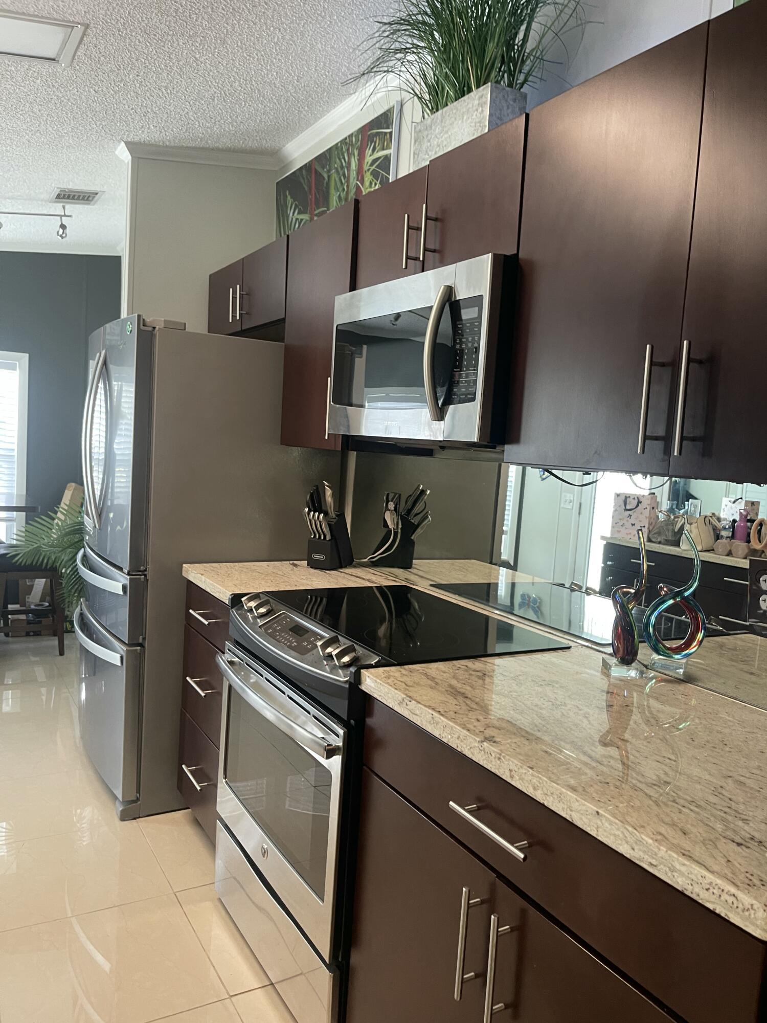 817 Sunglow Street Boynton Beach, FL 33436 - Photo 3 of 15 a kitchen with stainless steel appliances granite countertop a sink and a stove