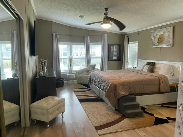 a bedroom with a bed couch and a chandelier