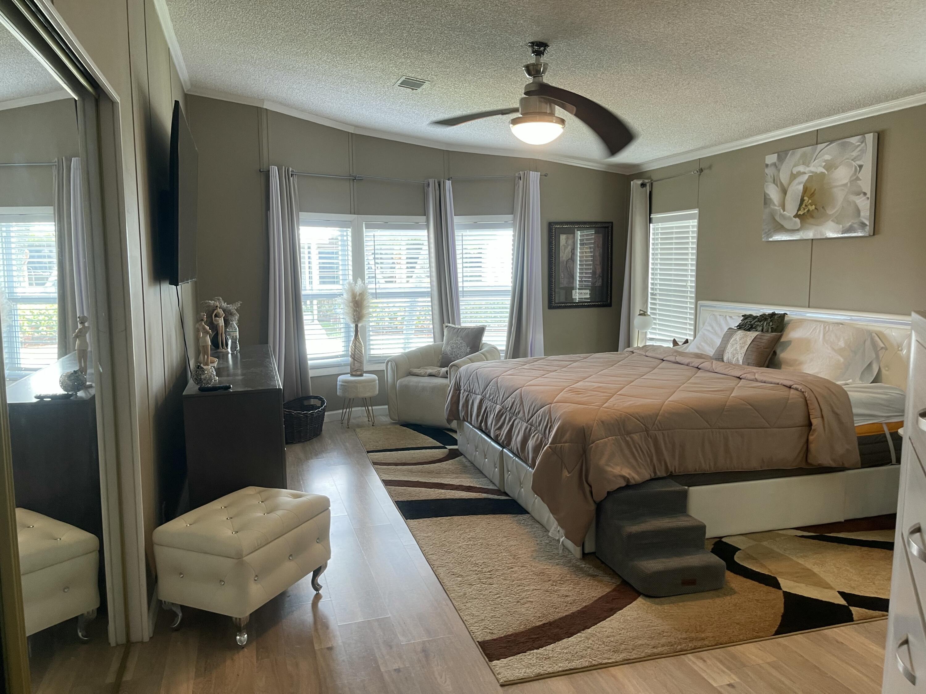 817 Sunglow Street Boynton Beach, FL 33436 - Photo 6 of 15 a bedroom with a bed couch and a chandelier