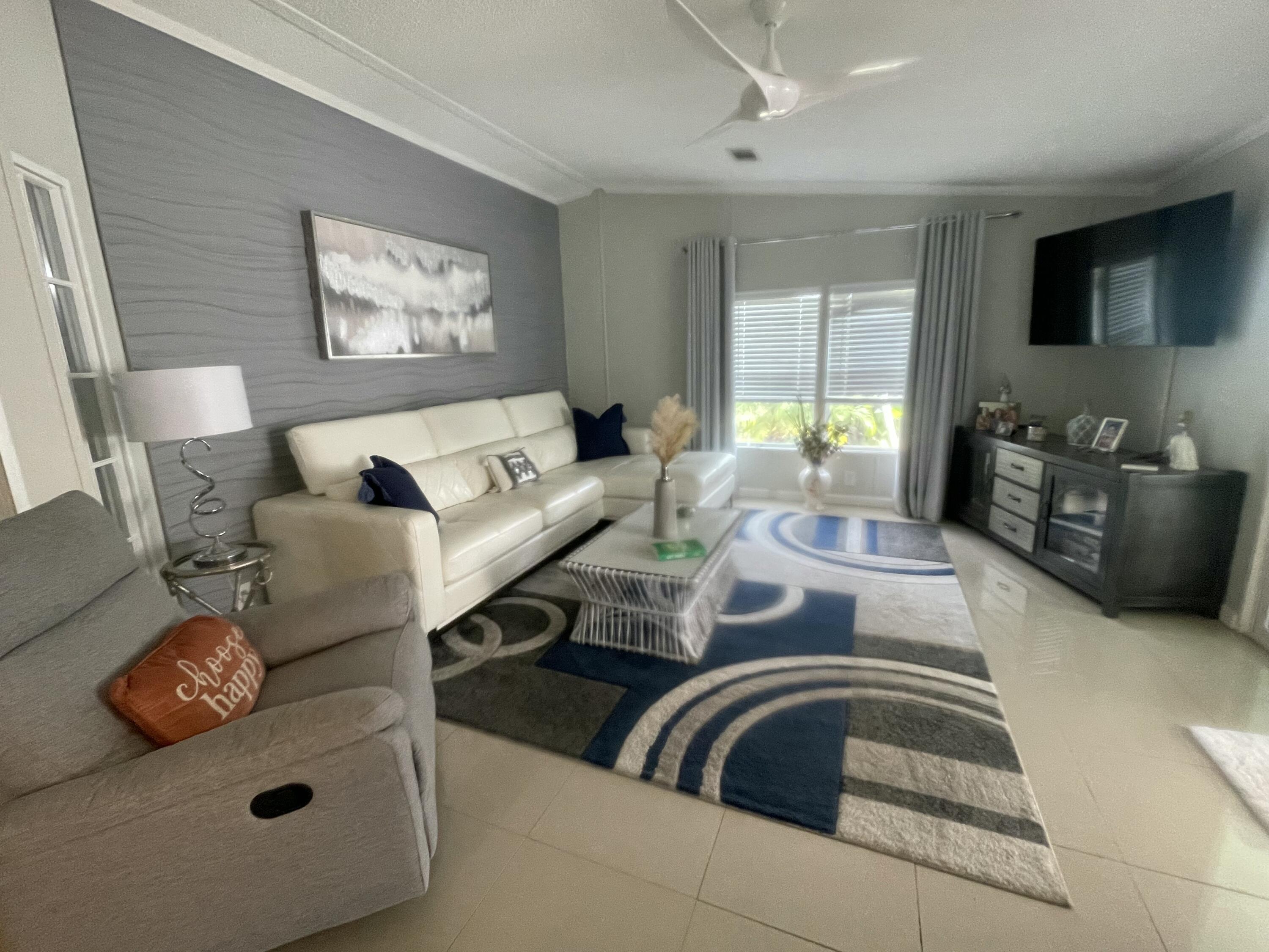 817 Sunglow Street Boynton Beach, FL 33436 - Photo 10 of 15 a living room with furniture and a flat screen tv