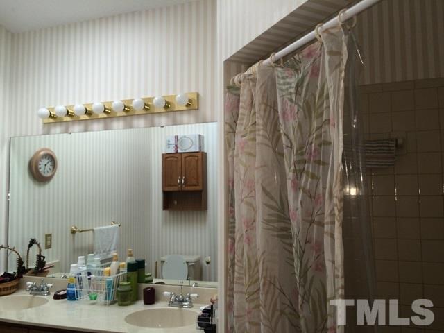 6000 Winterpointe Lane, Unit 303 Raleigh, NC 27606 - Photo 13 of 15 a bathroom with a sink and mirror
