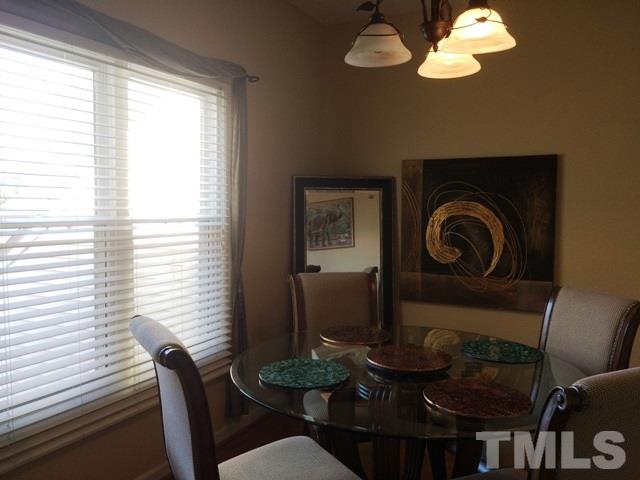 6000 Winterpointe Lane, Unit 303 Raleigh, NC 27606 - Photo 5 of 15 a dining room with furniture a large window and wooden floor