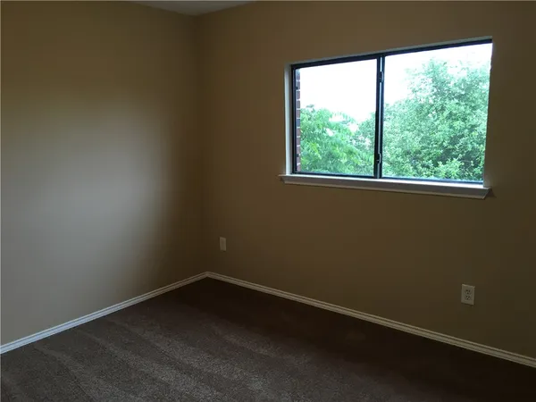 a view of a small space with wooden floor and a window