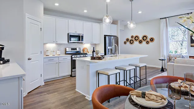 a living room with furniture a flat screen tv and kitchen view