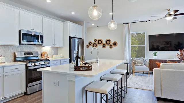 a kitchen with stainless steel appliances a stove a sink a refrigerator and a refrigerator