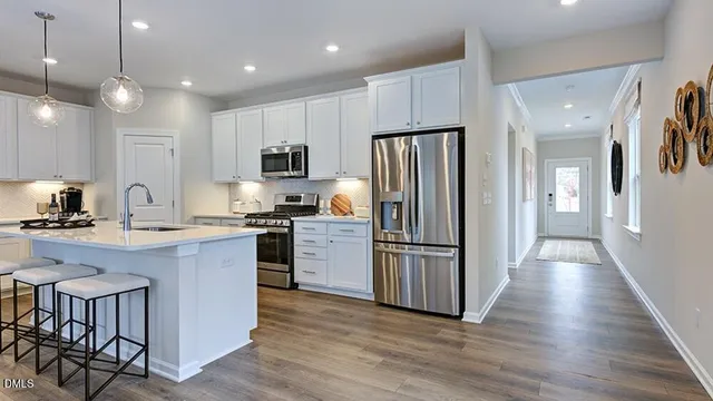 a living room with furniture kitchen and a chandelier