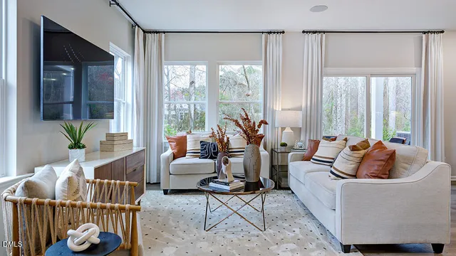 a living room with furniture a refrigerator and kitchen view
