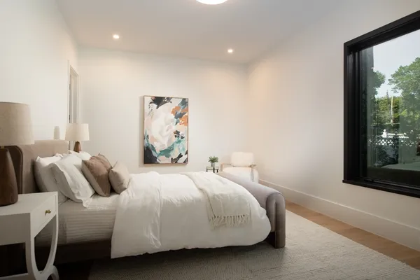 a bedroom with a bed and a large window