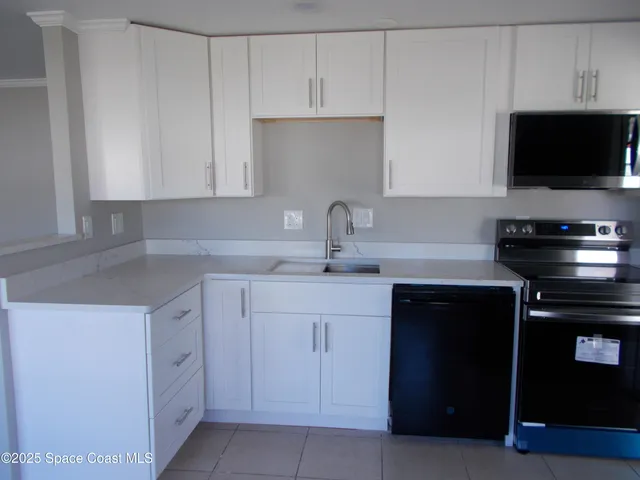a kitchen with white cabinets and a stove