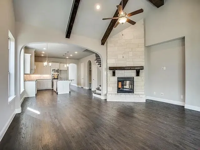 a view of an empty room with a fireplace and wooden floor