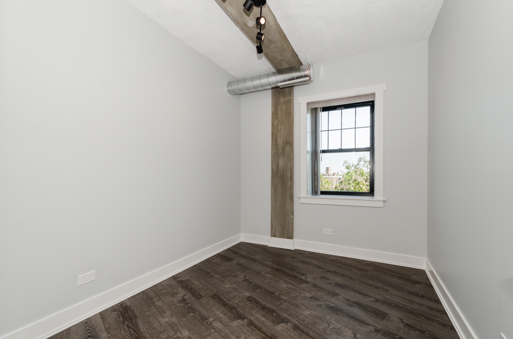 7645 North Sheridan Road, Unit 213 Chicago, IL 60626 - Photo 7 of 14 an empty room with wooden floor cabinet and windows