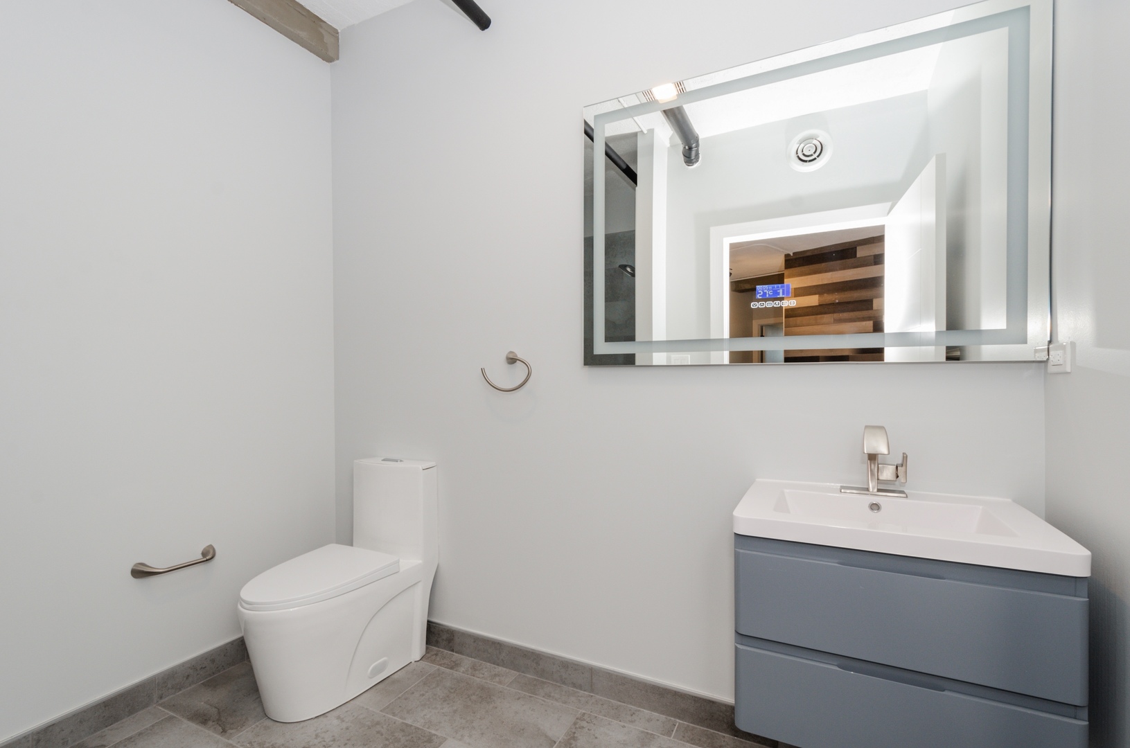 7645 North Sheridan Road, Unit 213 Chicago, IL 60626 - Photo 8 of 14 a bathroom with a toilet sink and mirror