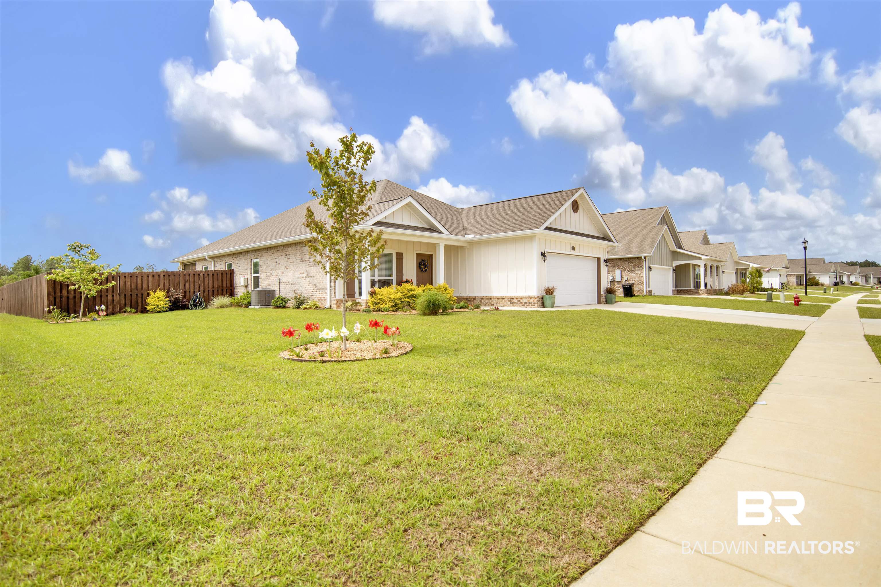 View of front of home with a shingled roof, driveway, a garage, board and batten siding, and covered porch