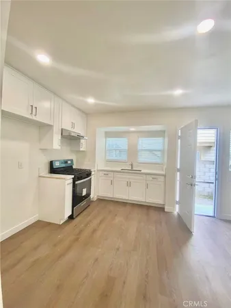 a view of a kitchen with wooden floor and electronic appliances