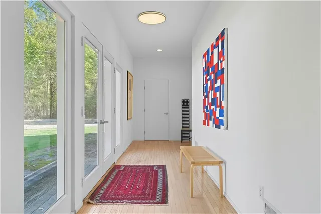 a view of a bedroom with wooden floor and windows