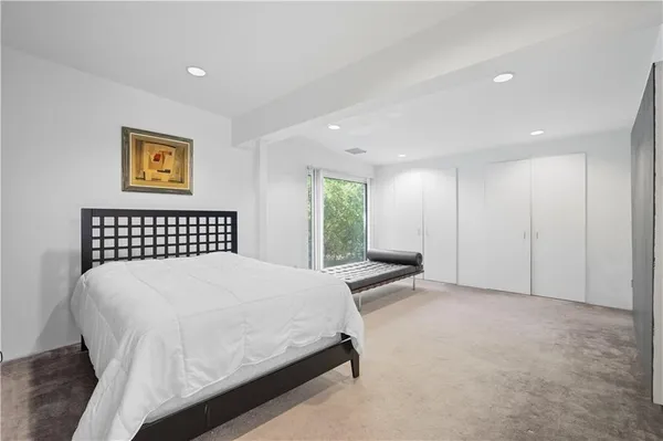 a spacious bedroom with a bed and a lamp